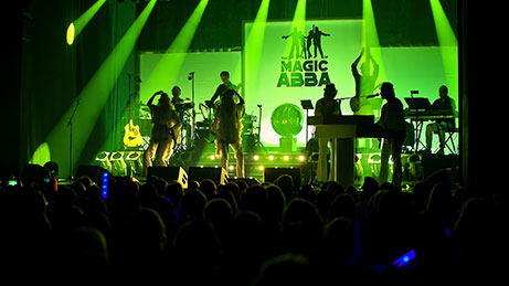 "The Magic of ABBA Bandmitglieder bei einem Live-Auftritt mit grünen Lichtern"